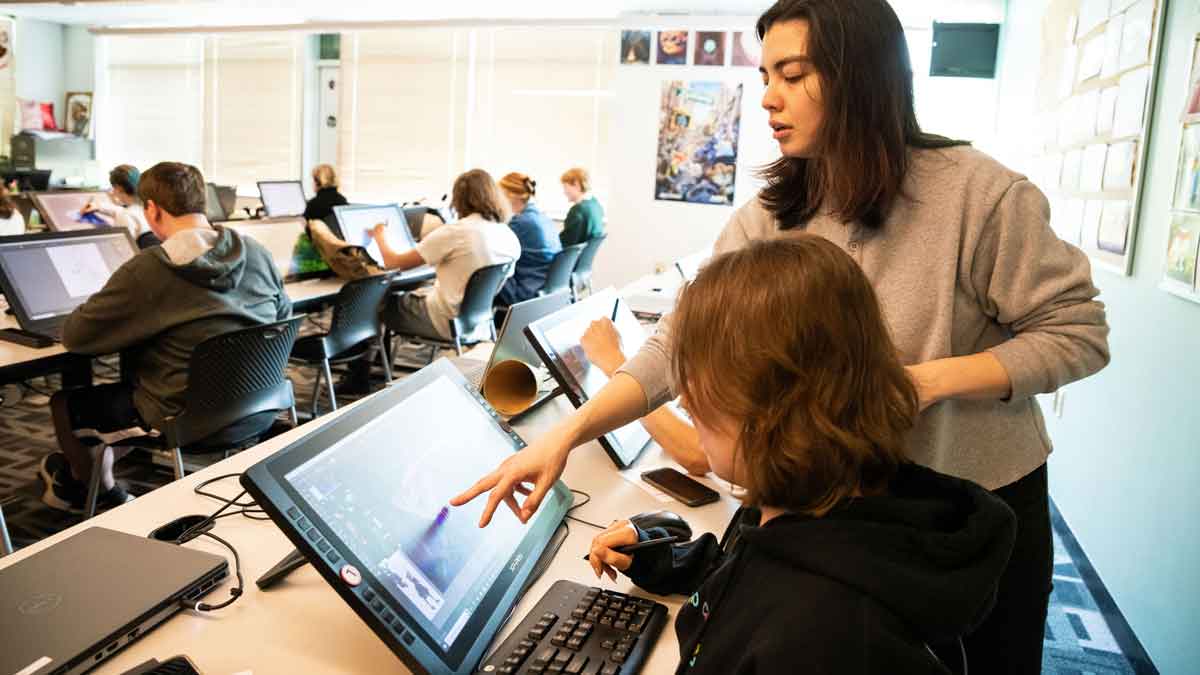 Photo of a DigiPen Academy teacher and student at a drawing tablet which links to the DigiPen Academy website