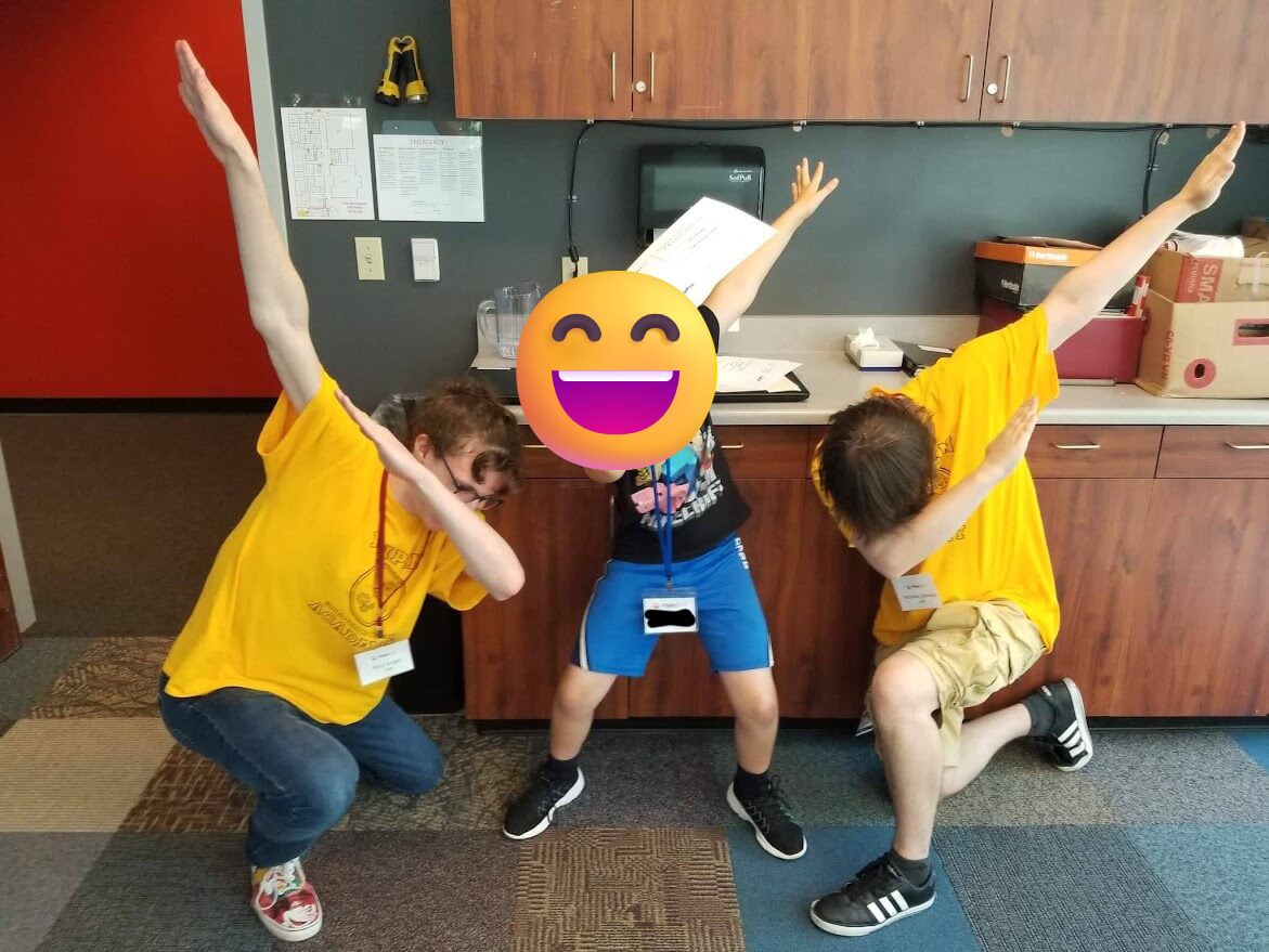 Photo of myself and another DigiPen Academy teacher dabbing with a young student who's face is protected for anonymity, all having a great time being silly
