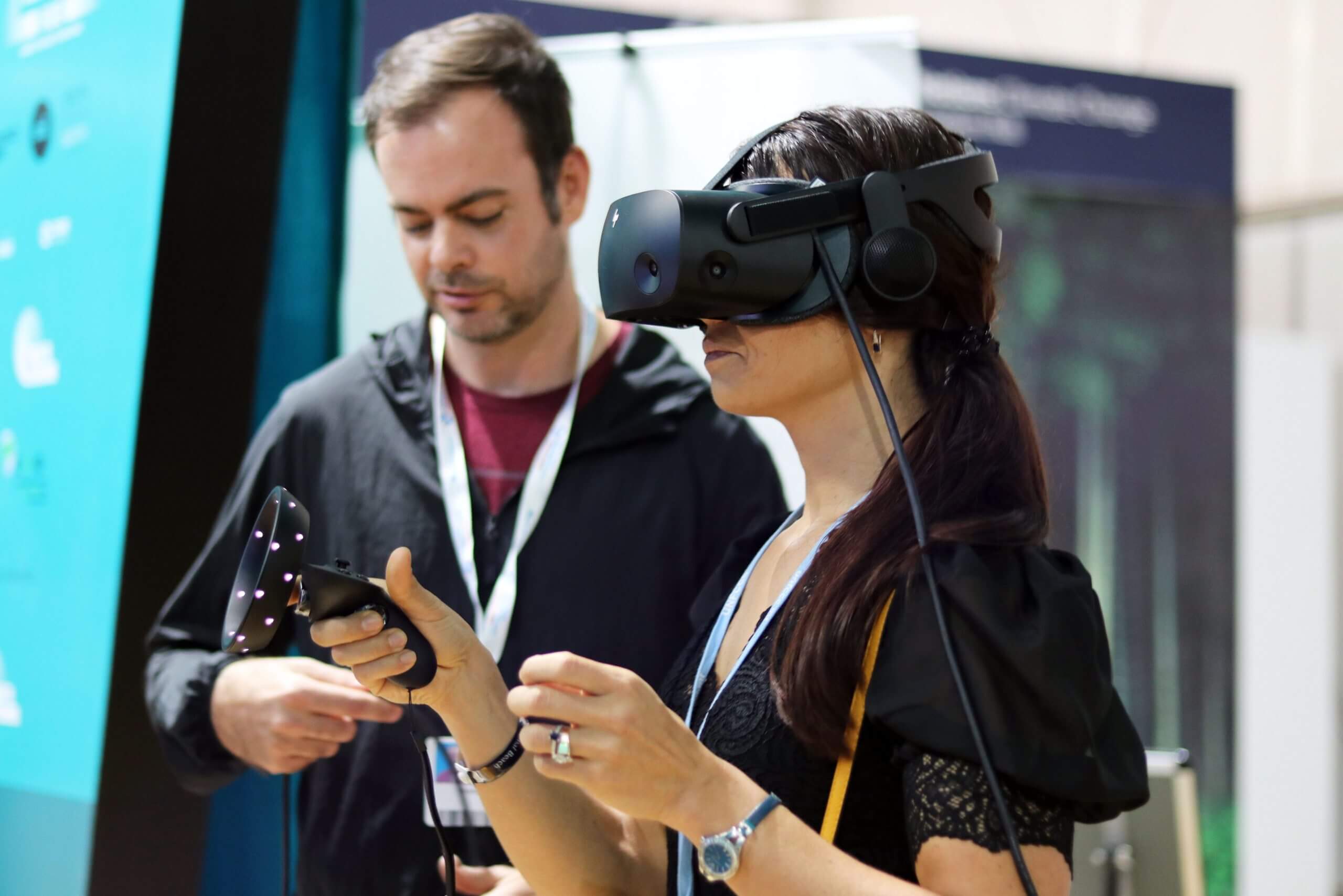 Photo of a woman in a VR headset with a man observing